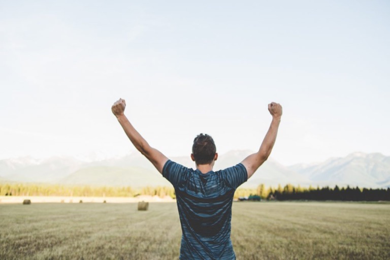 Triumphant man celebrating an excellent credit score in a field