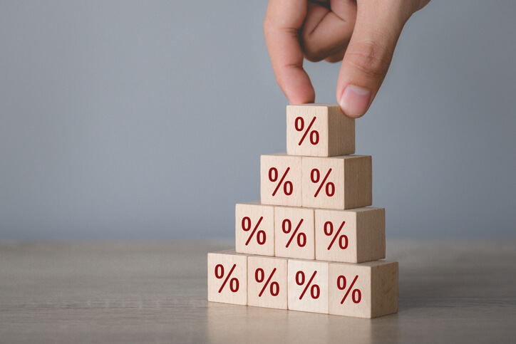 Person stacking cubes with percentage signs on them