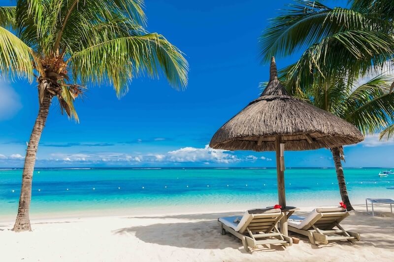 beach with two chairs on it facing the ocean
