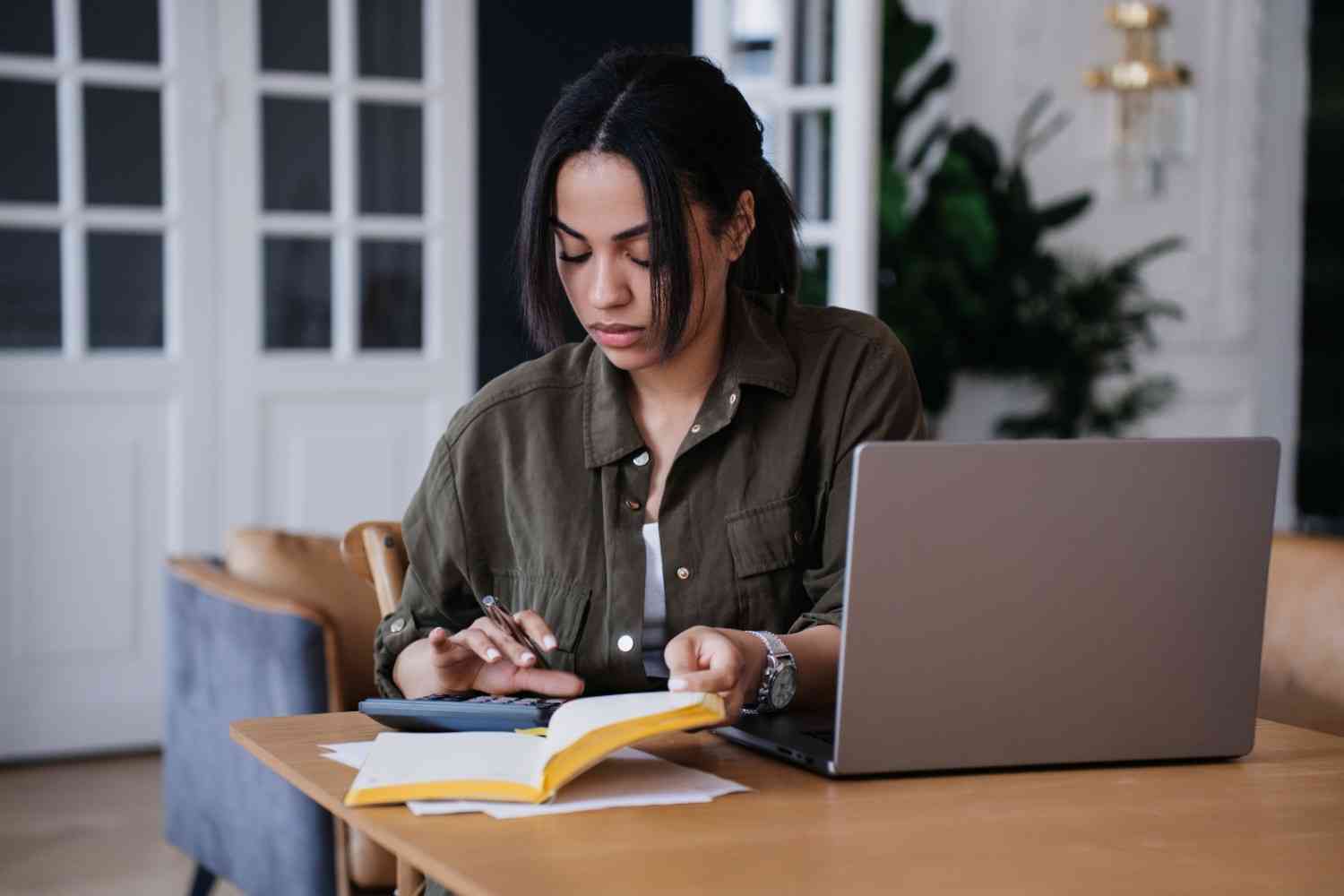 woman looking at paper and a laptop